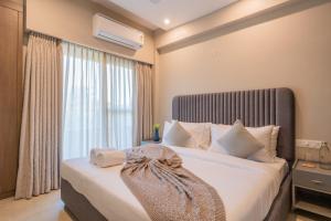 a bedroom with a large bed with a large window at Alaya Stays 3 BHK Veera Marina Pentahouse with Pool & Lift in Candolim
