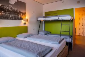 A bed or beds in a room at DORMERO BeHo Zugspitze