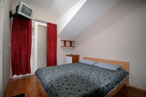 - une chambre avec un lit et une télévision murale dans l'établissement Mitko's Guest House, à Ohrid