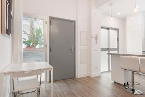 een witte keuken met een bureau en een raam bij Menaleka's House 7 in Málaga