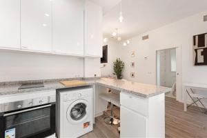 een witte keuken met een wasmachine en droger bij Menaleka's House 7 in Málaga +11 foto's