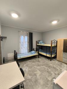 Hostel pracowniczy ORBITA في فولكا كوسوفسكا: غرفة بها سريرين بطابقين وطاولة