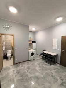 Hostel pracowniczy ORBITA في فولكا كوسوفسكا: مطبخ وغرفة طعام مع طاولة وغسالة ملابس