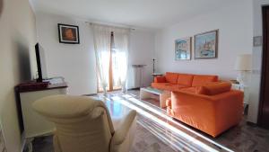 a living room with an orange couch and chairs at Colleoni Lodge CASA VACANZE CON 2 APPARTAMENTI INDIPENDENTI in Verdellino