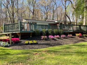 a house with decks and flowers in a yard at Mountain Aire Cottages, Inn, & Glamping in Clayton