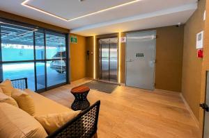 a living room with a couch and a glass door at Intermares Quartz Studio 2 Pessoas 150m Praia in Ilha da Restinga