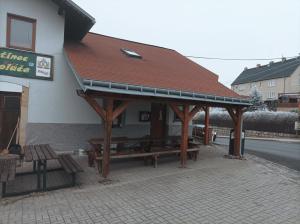 a pavilion with wooden benches in front of a building at Hostinec U Koláče in Jablonné v Podještědí
