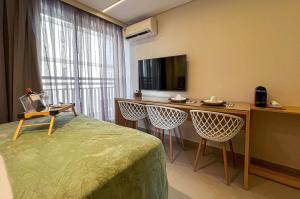 a hotel room with a bed and a table and chairs at Intermares Quartz Studio Luxo 3 Pessoas 150m Praia in Ilha da Restinga