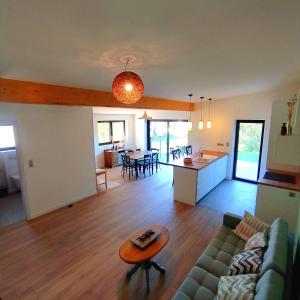 a living room and kitchen with a couch and a table at Charmant Cottage in Châtenois +13 photos