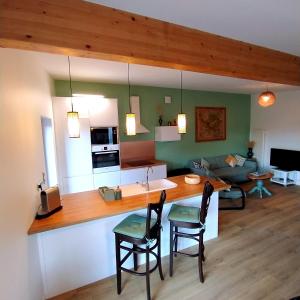 a kitchen and living room with a table and chairs at Charmant Cottage in Châtenois