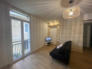 a living room with a couch and a large window at Appartement neuf, plein centre Latresne-Gironde in Latresne