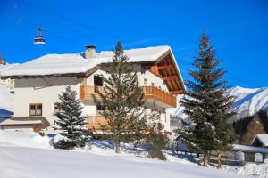 a building in the snow with trees and a ski lift at Apart Prieth Samnaun in Samnaun