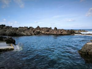 una piscina d'acqua accanto ad alcune rocce nell'oceano di Vivenda "Porto de Abrigo" a Biscoitos