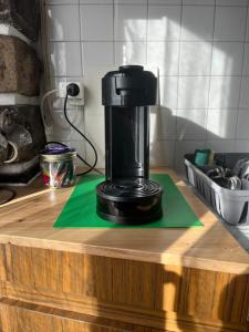a black coffee maker sitting on a wooden counter at Studio cosy avec borne de recharge in Saint-Germain-Lembron