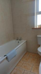 a bathroom with a bath tub and a toilet at High Meadow House in Duncormick +15 photos