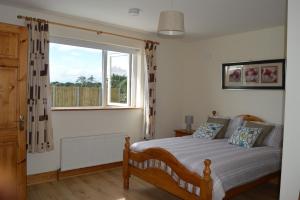 a bedroom with a bed and a large window at High Meadow House in Duncormick