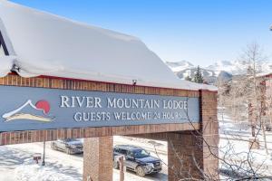 a sign for the river mountain lodge in the snow at River Mountain Lodge in Breckenridge