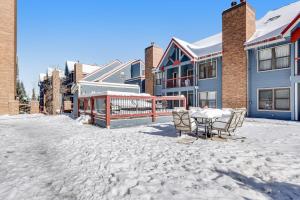 a patio with a table and chairs in the snow at River Mountain Lodge in Breckenridge +7 photos