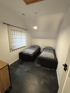 two beds in a small room with a window at Skrzynia in Skrzynia