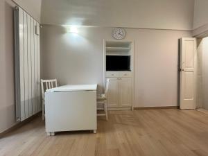 a white room with a desk and a clock on the wall at Dimora Al Nonnino in Noci