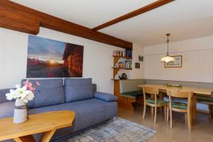a living room with a blue couch and a table at Haus Maringele in Nesselwängle