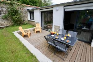 a patio with a table and chairs on a deck at Le Forest - 400m centre ville de Pontivy in Pontivy