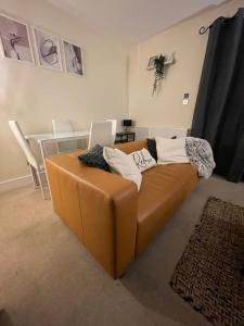 a brown couch with pillows on it in a living room at 4 bed house perfect for contractors in Coseley