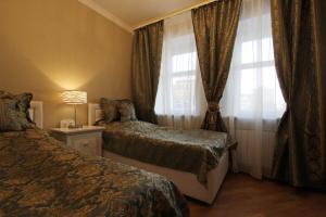 sypialnia z 2 łóżkami i oknem z zasłonami w obiekcie Apollo w Petersburgu