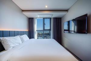 a bedroom with a large bed and a large window at The Western Busan Hotel By STAYNEO in Busan +66 photos