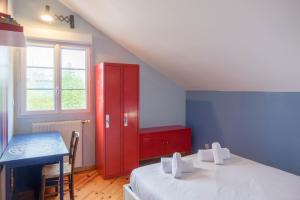 a room with two beds and a red cabinet at La Petite Maison au calme - 2 chambres - à 200m des Bords de Loire in Saint-Jean-de-Braye