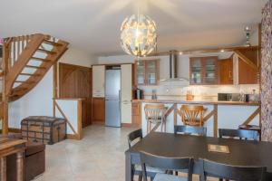 a kitchen and dining room with a table and chairs at La Petite Maison au calme - 2 chambres - à 200m des Bords de Loire in Saint-Jean-de-Braye +7 photos