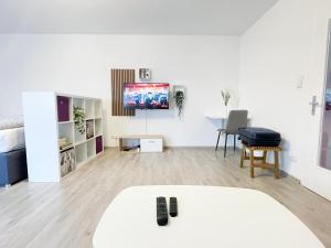 レーオンベルクにあるPerfekte 1,5 Wohnung Zentral in Leonberg gegenüber Einkaufzentrumの白い部屋(ベッド1台、壁にテレビ付)