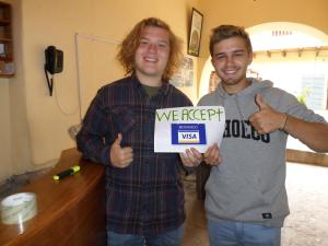 two men holding up a sign that says we reject at OkiDoki Cusco Hostal in Cusco