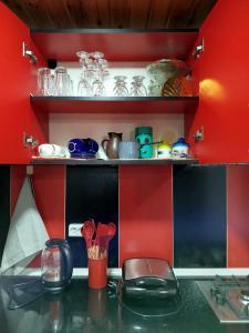 a kitchen with red walls and a counter with dishes at Tsemi sweet home in Borjomi +12 photos