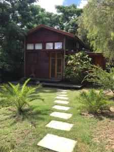 a small wooden house with a pathway in front of it at Cabaña de madera para 4 personas in Playa Hermosa