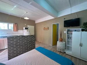 a living room with a kitchen and a refrigerator at Bavarian Suites in Colón