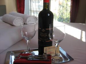 una bottiglia di vino e due bicchieri su un vassoio di Mitko's Guest House a Ohrid