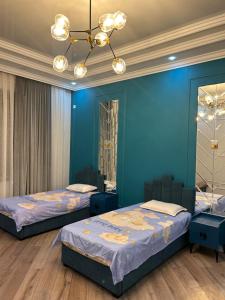 two beds in a room with blue walls and a chandelier at Эксклюзивный Дом Самарканда in Samarkand +28 photos