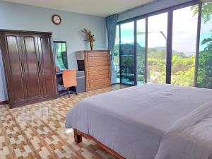 a bedroom with a bed and a desk and windows at Seaview Eagles Nest Apartment 3 in Nai Harn Beach +32 photos