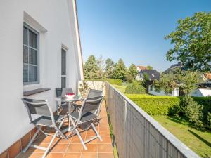 a patio with chairs and a table on a balcony at Abenteuer Zingst, FW Kormoran 10 in Zingst