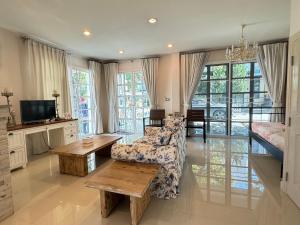 a living room with a couch and a table at PY house khaoyai in Khanong Phra