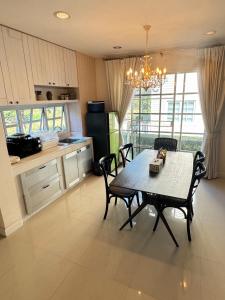 a kitchen with a table and chairs in a room at PY house khaoyai in Khanong Phra