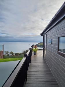 a wooden walkway leading to a house with a view of the ocean at Aurorabelle Lodge in Brixham