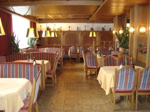 una sala da pranzo con tavoli, sedie e luci di Hotel Sonnhof a Wiesing