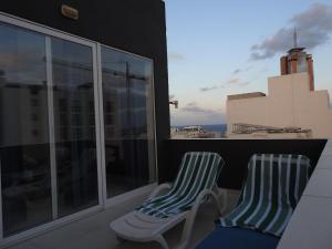 two chairs sitting on top of a balcony at Magnolia Guest House in St. Julianʼs