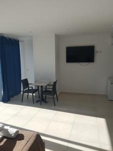 a room with a table and chairs and a tv on the wall at Magnolia Guest House in St. Julianʼs