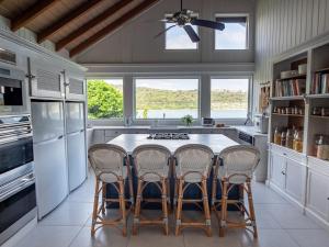 a kitchen with a table and four chairs at The Seahouse Antigua SEAFRONT in Bats Cave