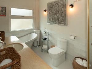 a bathroom with a toilet and a tub and a sink at The Seahouse Antigua SEAFRONT in Bats Cave +85 photos