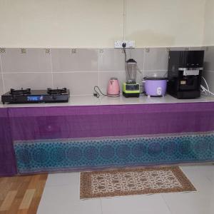un piano da lavoro viola con sopra degli elettrodomestici di Homestay Lavender a Kajang