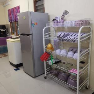 una cucina con frigorifero e un carrello con piatti di Homestay Lavender a Kajang